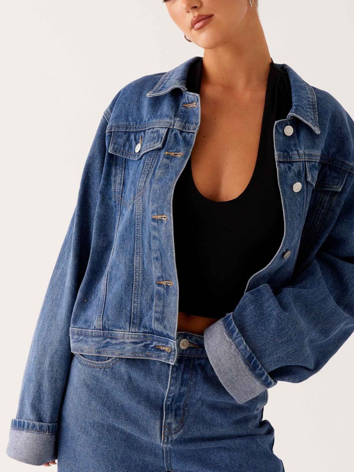 Dark blue oversized denim jacket with button-down front and cropped fit from Trendsi, casual and stylish for everyday wear.