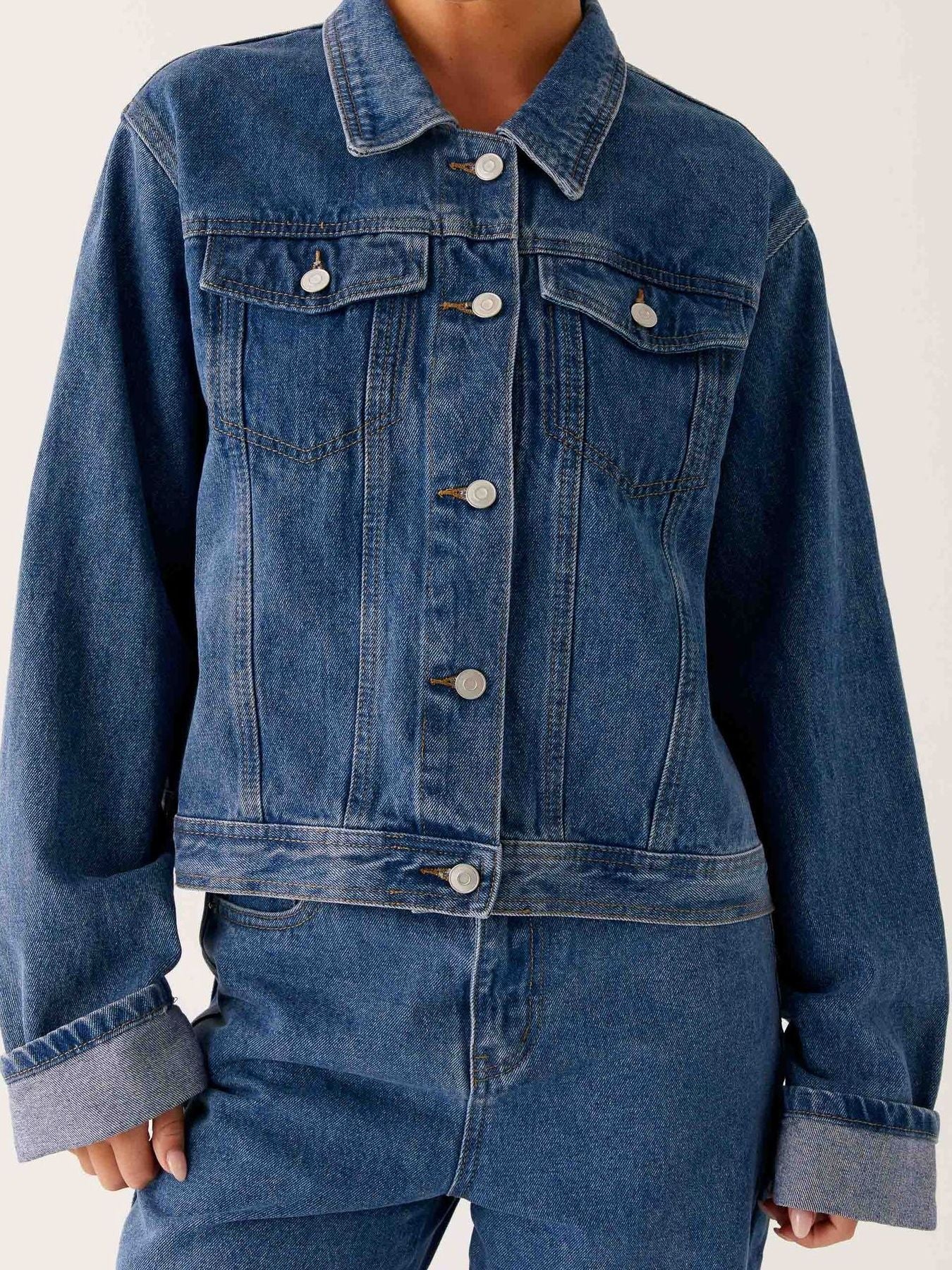 Dark blue button-down cropped oversized denim jacket from Trendsi, featuring classic denim texture and relaxed fit.