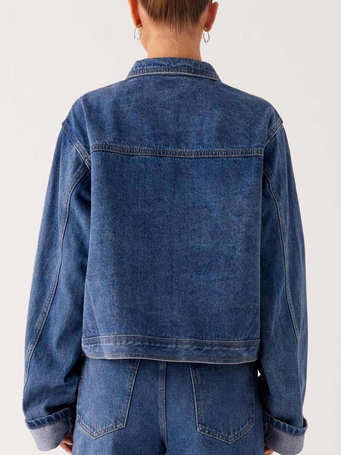 Dark blue oversized denim jacket with button-down front, cropped style, from Trendsi, featuring a classic denim look.