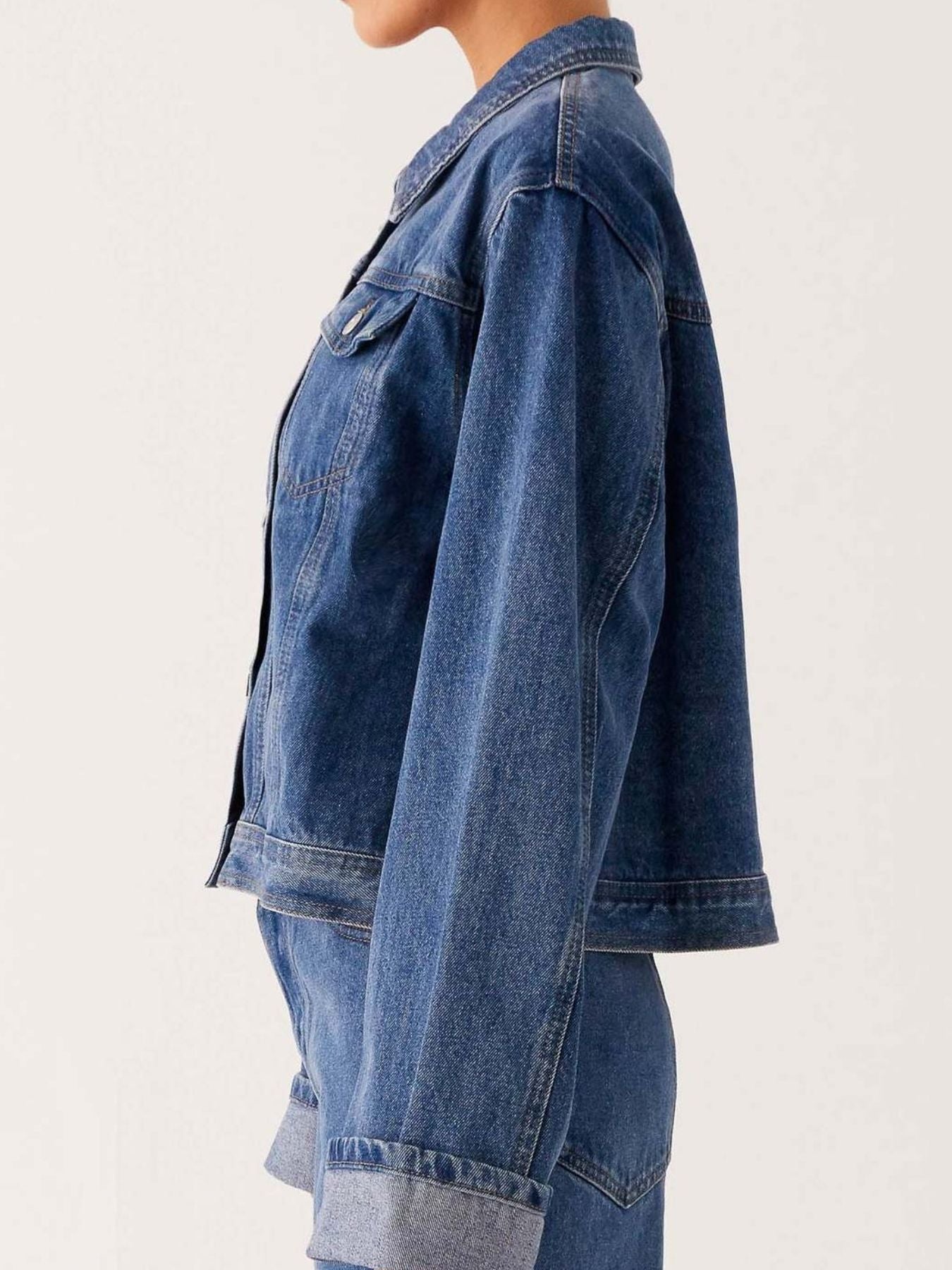 Dark blue oversized denim jacket with button-down front, cropped fit, and classic denim texture from Trendsi.