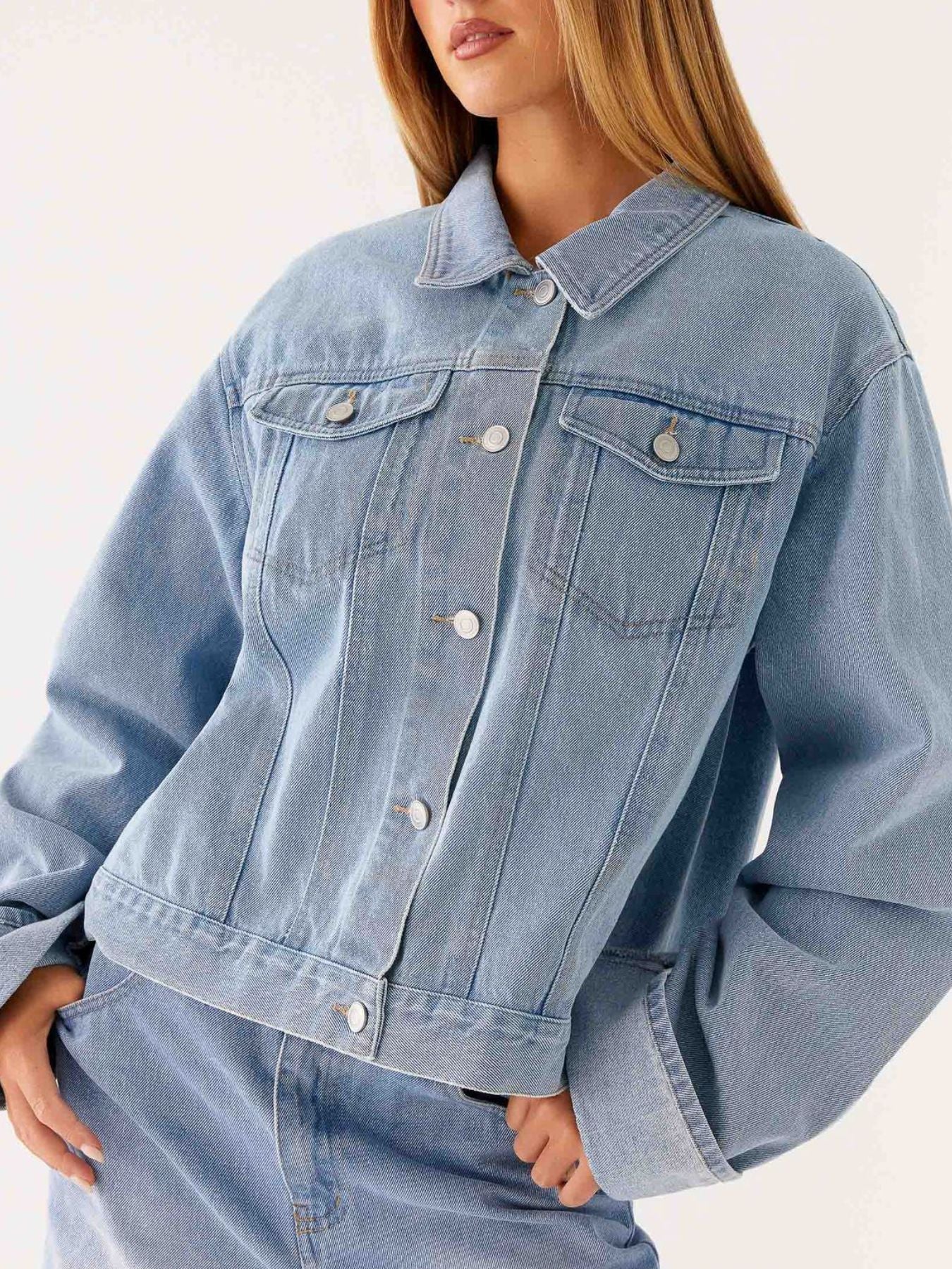 Dark blue oversized denim jacket with button-down front, cropped style, by Trendsi, displayed on a plain background.