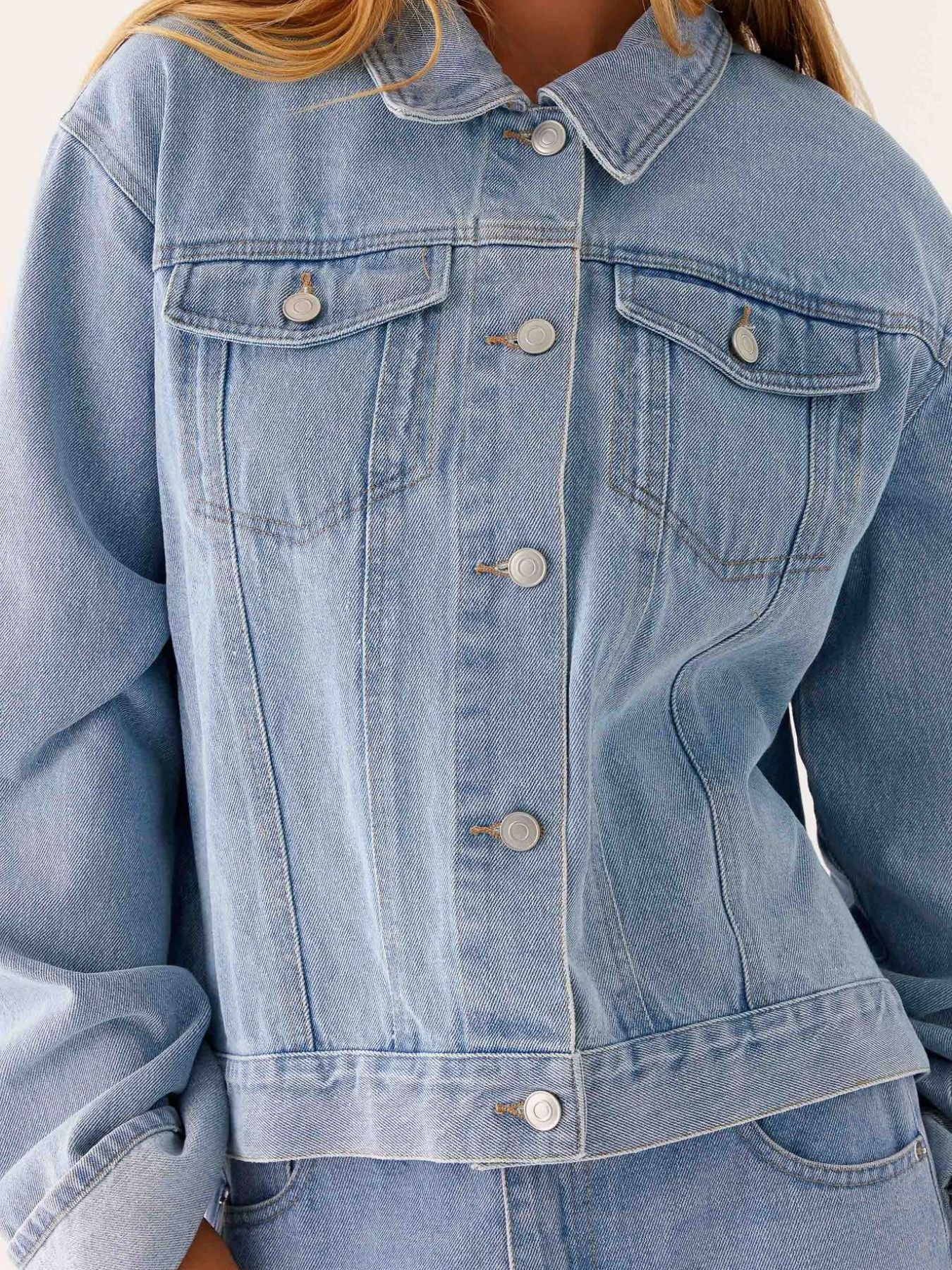 Dark blue oversized denim jacket with button-down front, cropped fit, and classic denim texture from Trendsi.