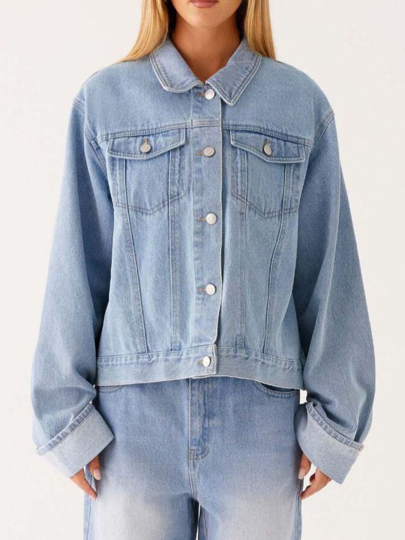 Dark blue oversized denim jacket with button-down front, cropped fit, and classic denim texture from Trendsi.