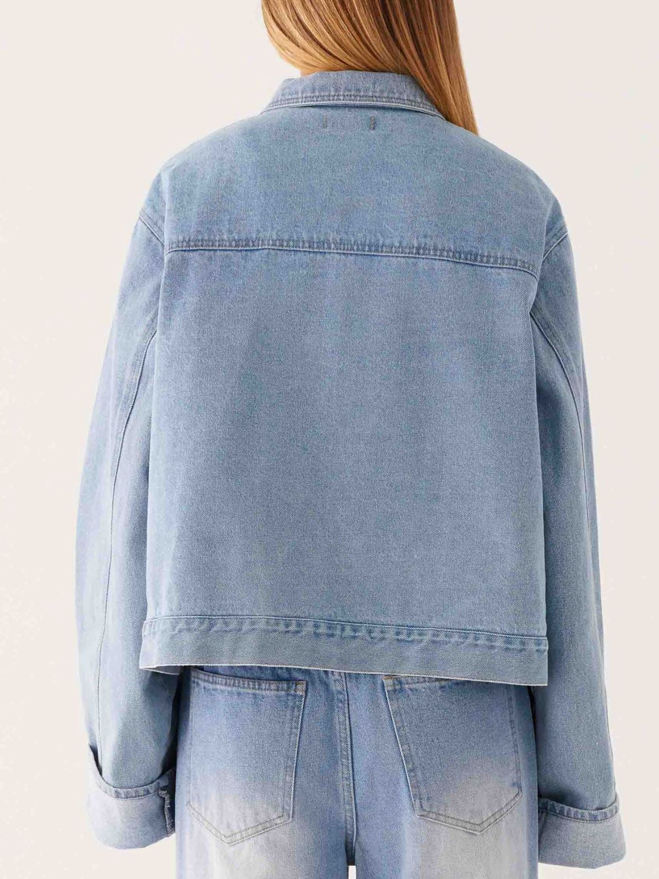Dark blue oversized denim jacket with button-down front and cropped length, stylish Trendsi denim outerwear.