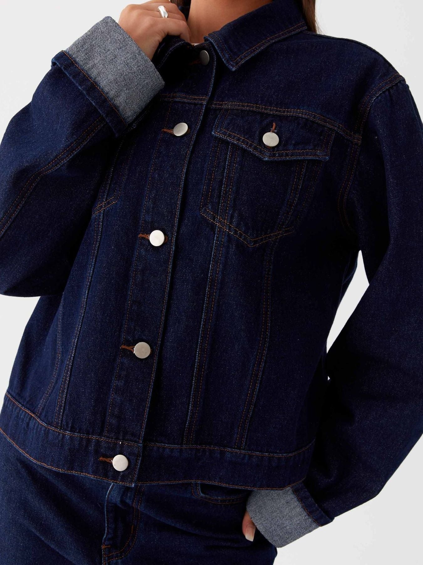Dark blue oversized denim jacket with button-down front, cropped fit, and classic denim styling by Trendsi.