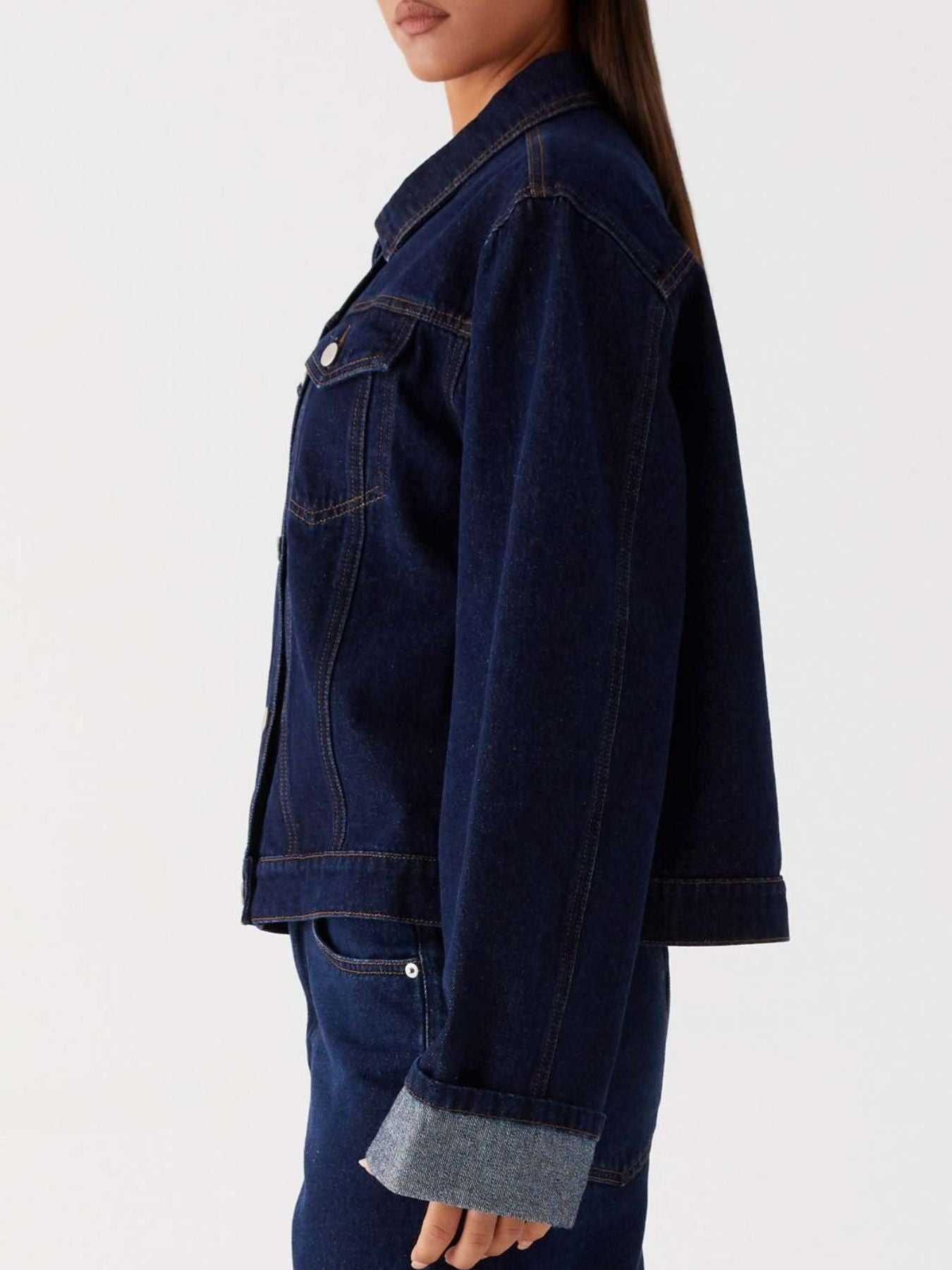 Dark blue oversized denim jacket with button-down front, cropped fit, from Trendsi, styled with long sleeves and classic denim texture.