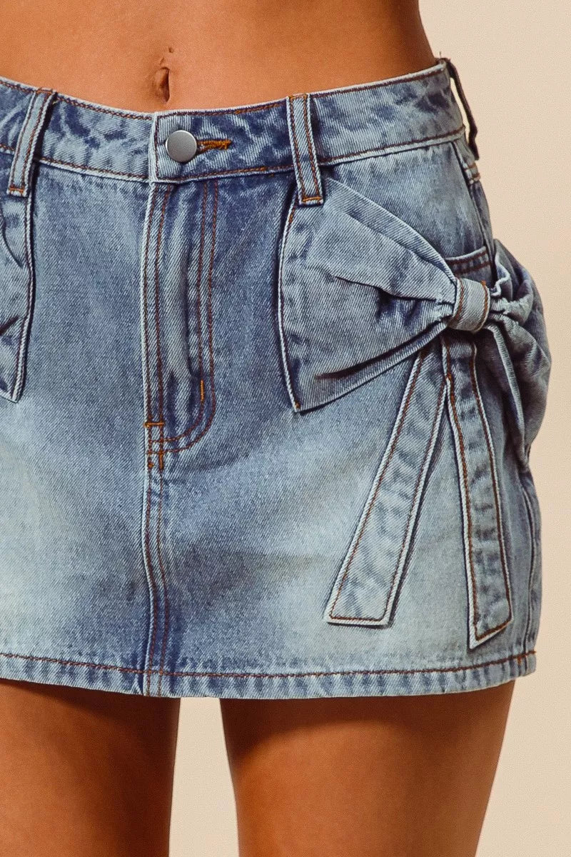 Trendsi SO ME Bow Knot Pocket Denim Mini Skirt featuring a stylish bow knot detail and classic denim fabric.