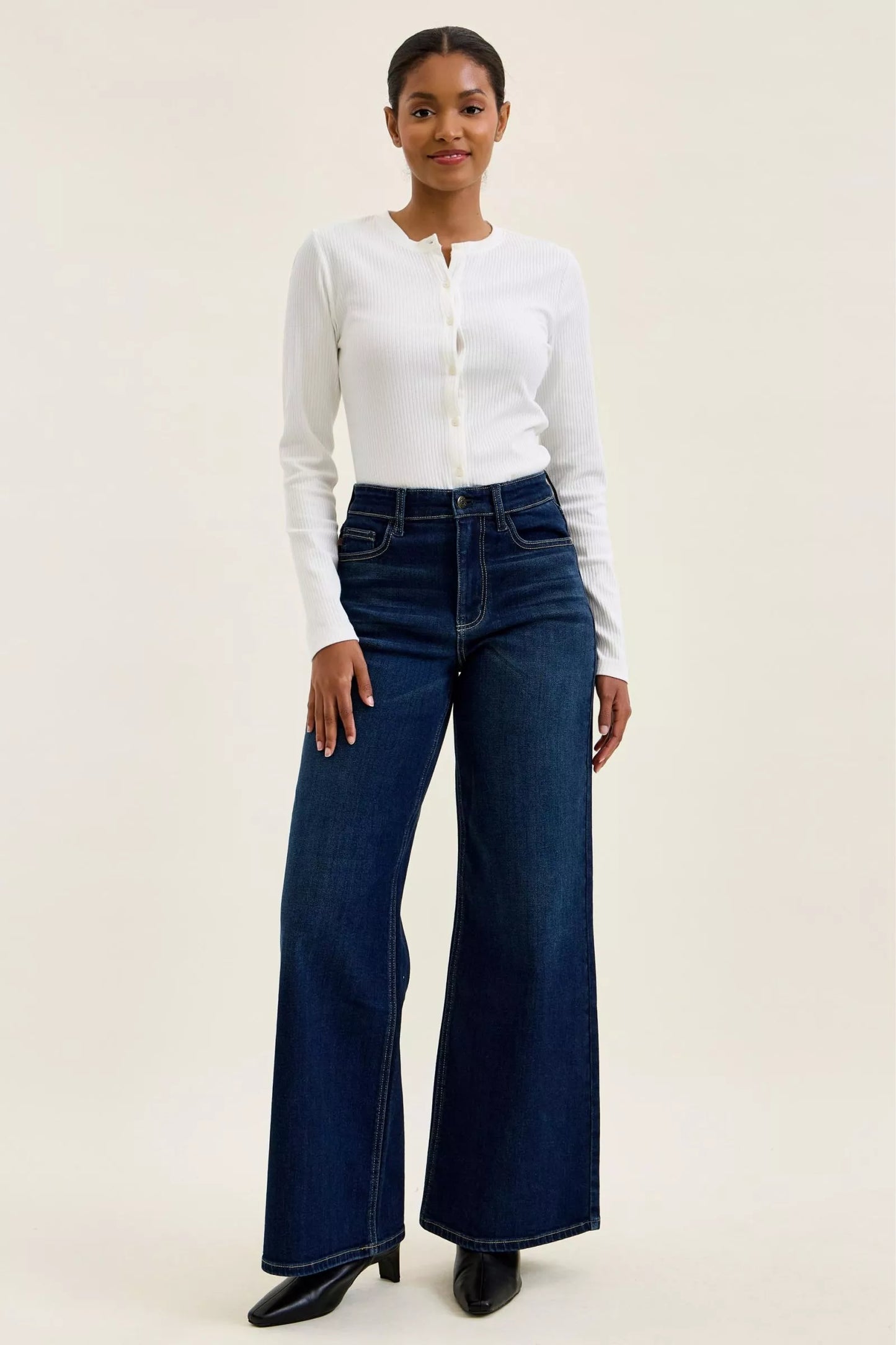 Judy Blue high-waisted wide-leg dark wash jeans with classic five-pocket design and relaxed fit, displayed on a model.