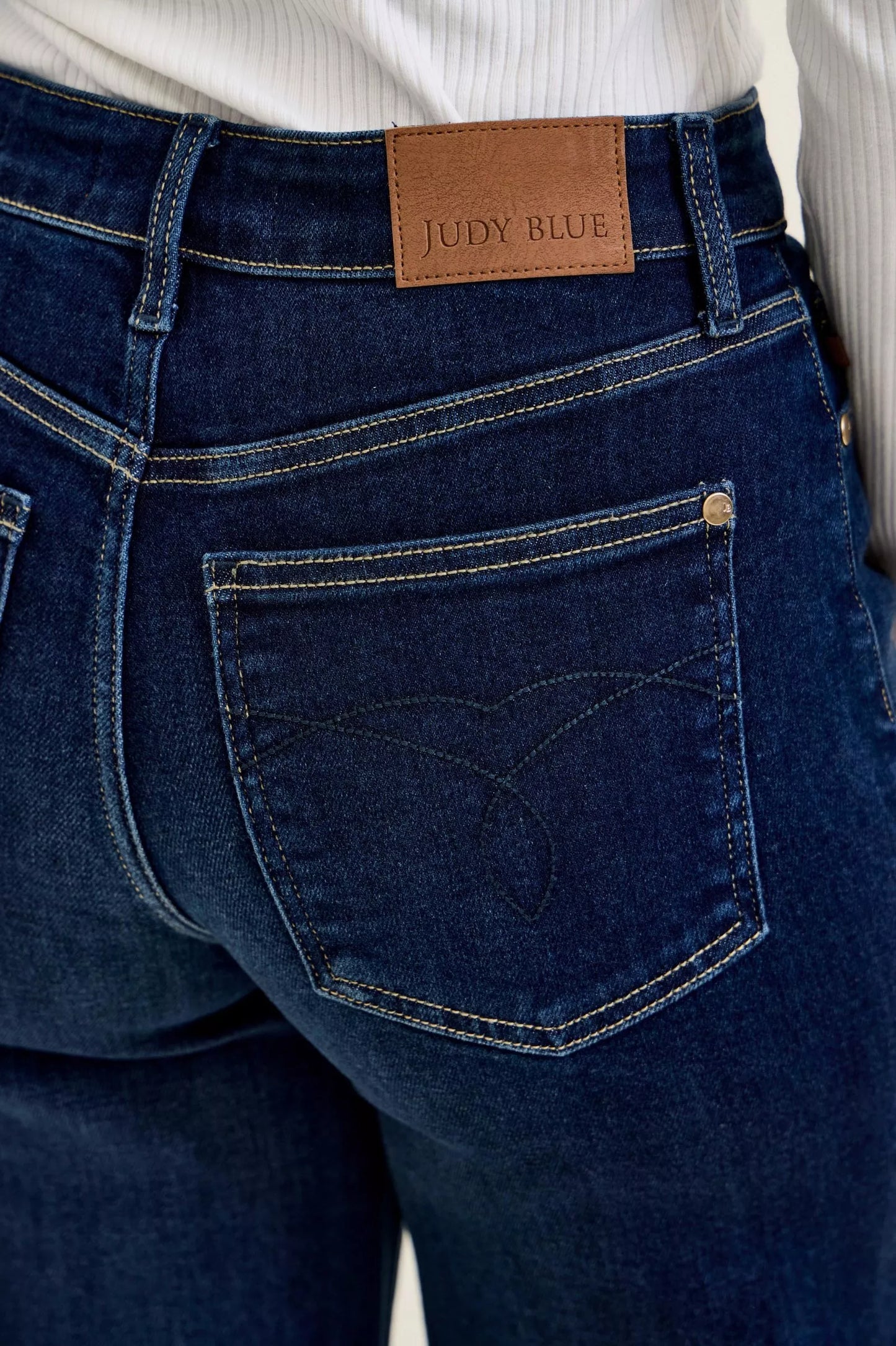 Dark wash Judy Blue high-waisted wide-leg jeans with classic denim texture and relaxed fit, styled on a model.