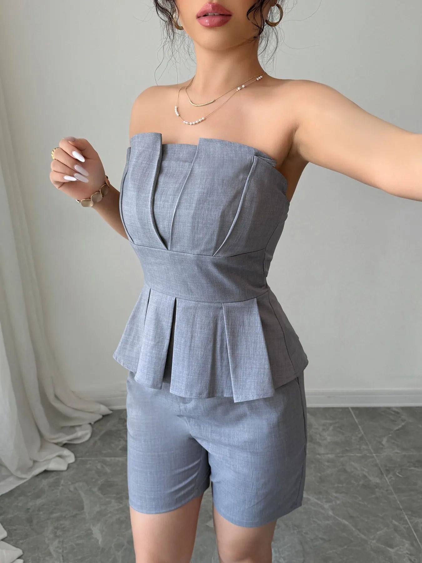 Gray strapless peplum top and matching shorts two-piece set by Trendsi, stylish and perfect for casual or summer wear.