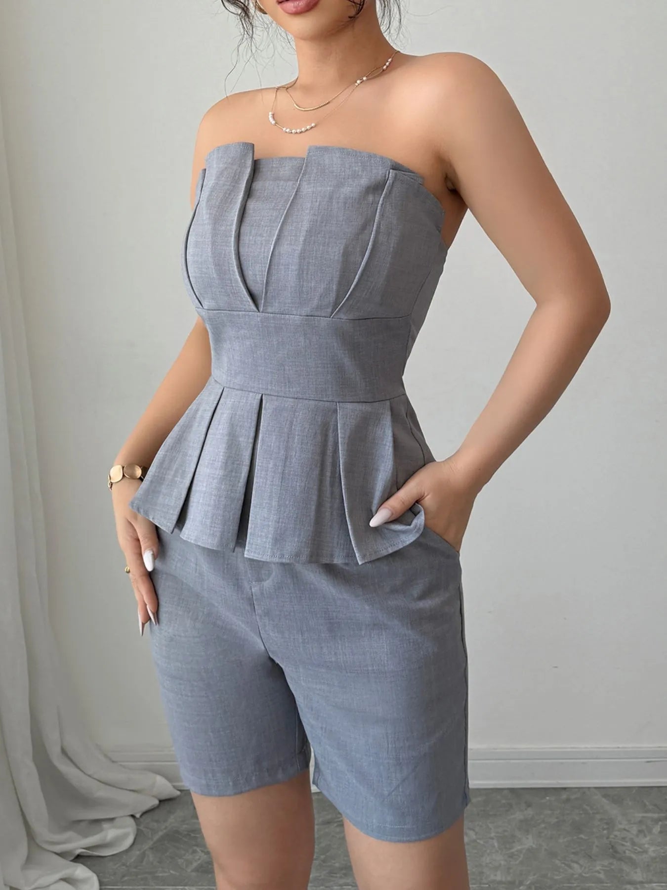 Gray strapless peplum top and shorts two-piece set from Trendsi, featuring a stylish, coordinated casual outfit.
