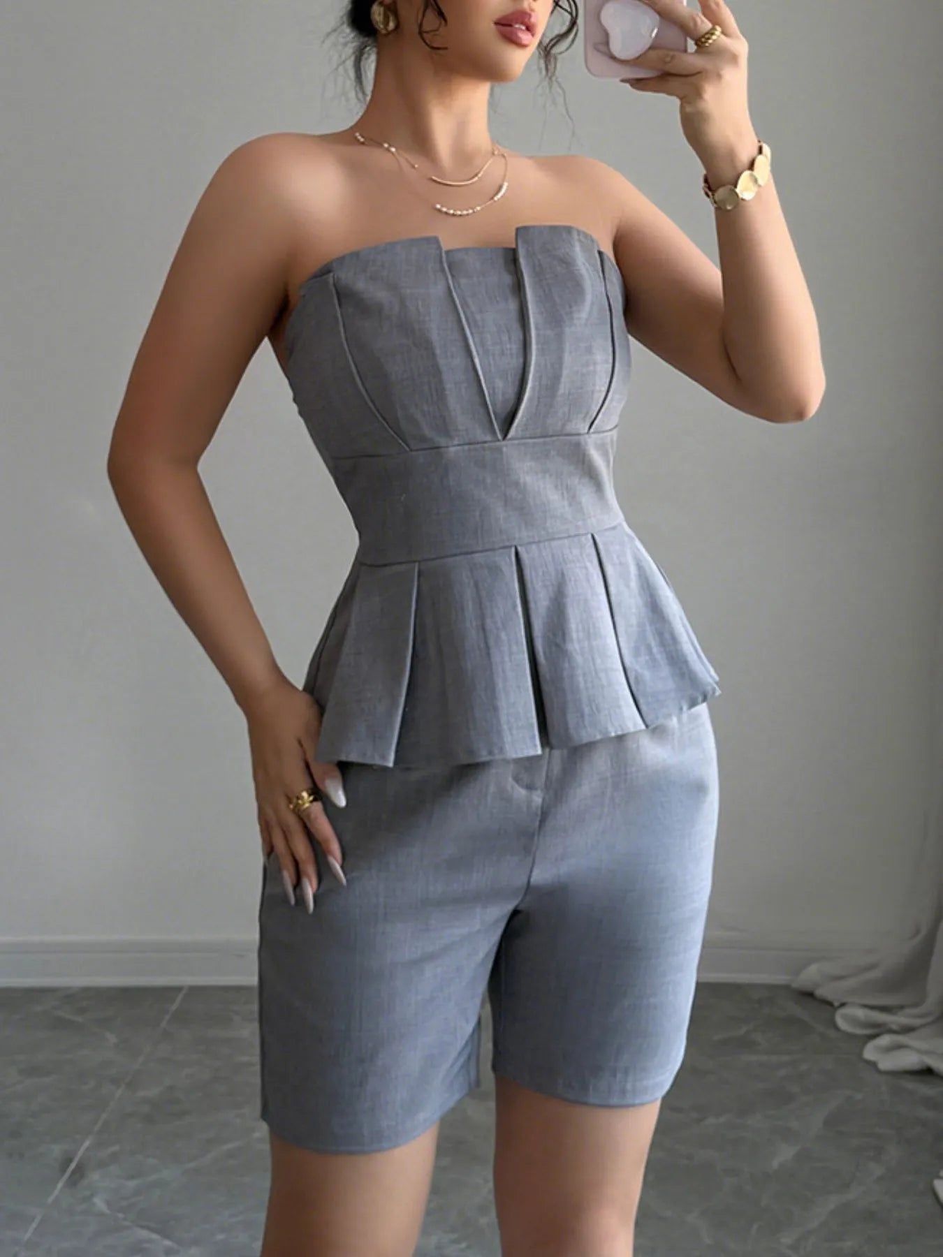 Gray strapless peplum top and shorts two-piece set from Trendsi, styled for a trendy summer look.
