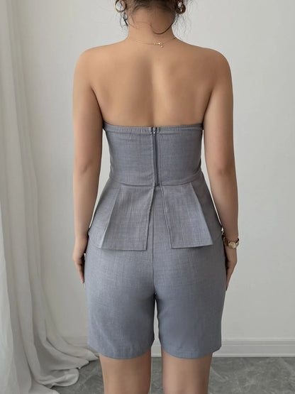 Gray strapless peplum top and matching shorts two-piece set by Trendsi, styled for a casual or trendy look.