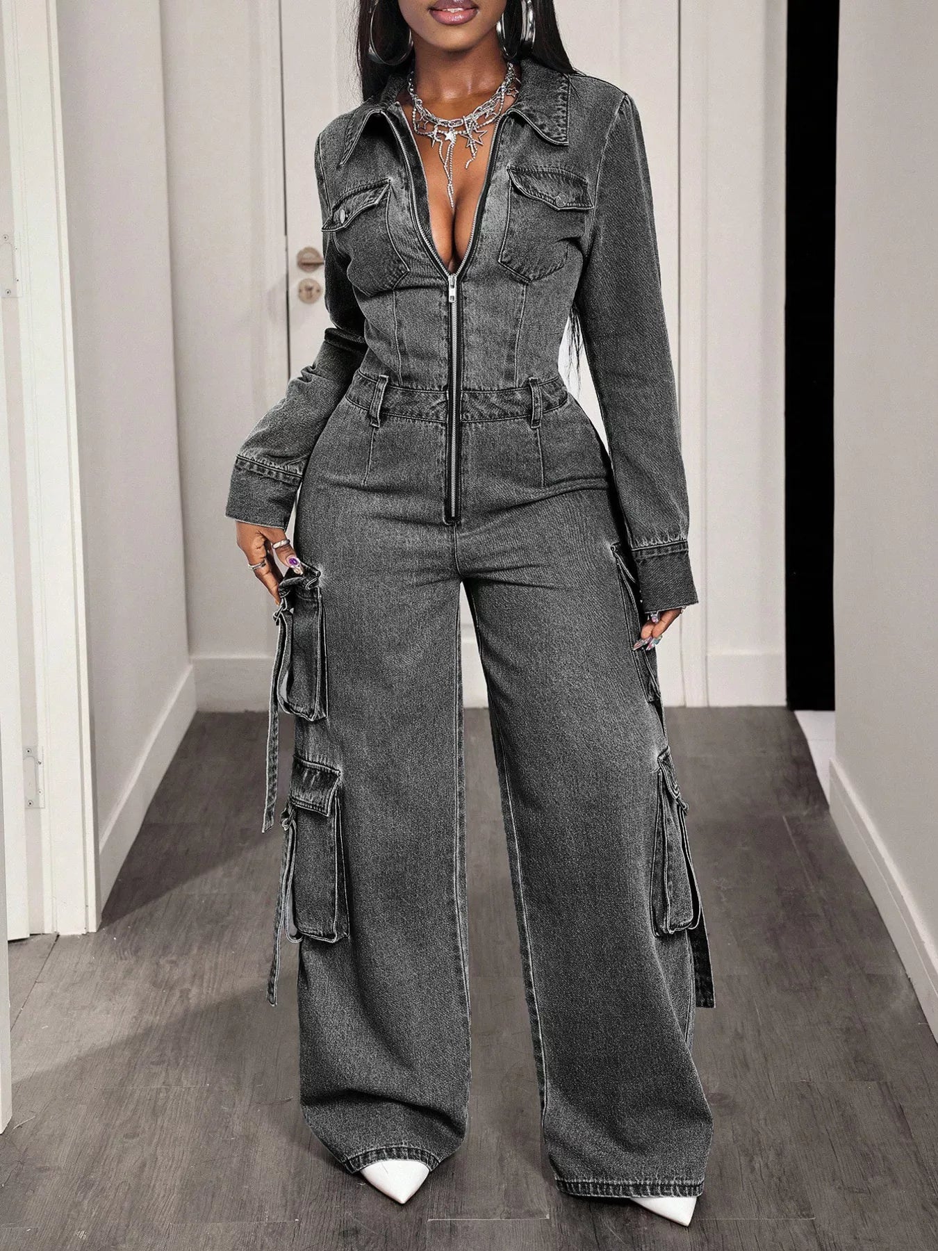 Denim jumpsuit with zip front, wide-leg cargo pants, and adjustable straps, styled in trendy blue denim fabric.