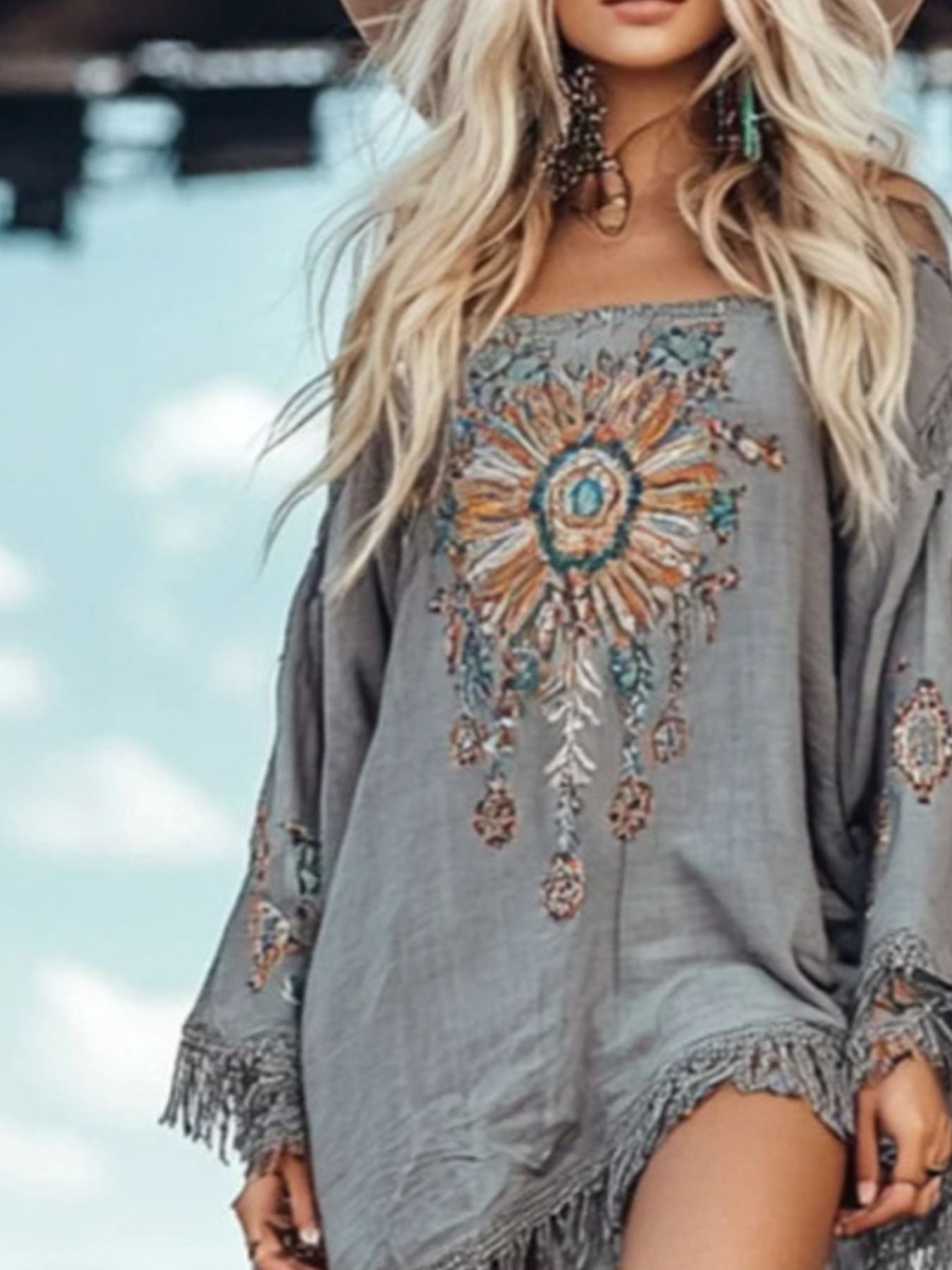 Long sleeve mini dress with fringe hem by Trendsi, featuring a stylish and trendy design with flowing fringes at the hem.