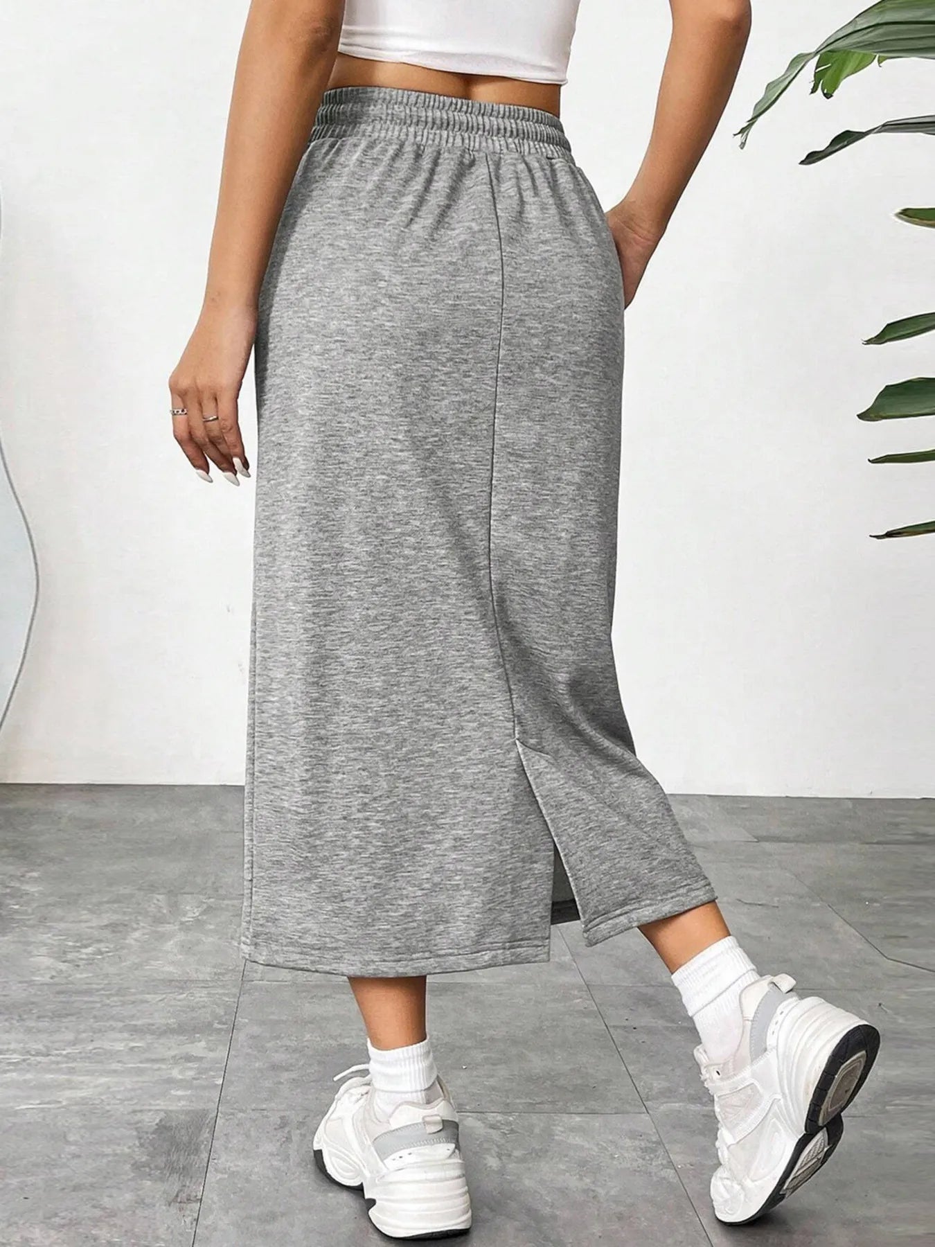 Trendsi slit drawstring midi skirt with high waist and side slit, made of soft fabric, shown on a model.