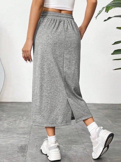Trendsi slit drawstring midi skirt with high waist and side slit, made of soft fabric, shown on a model.