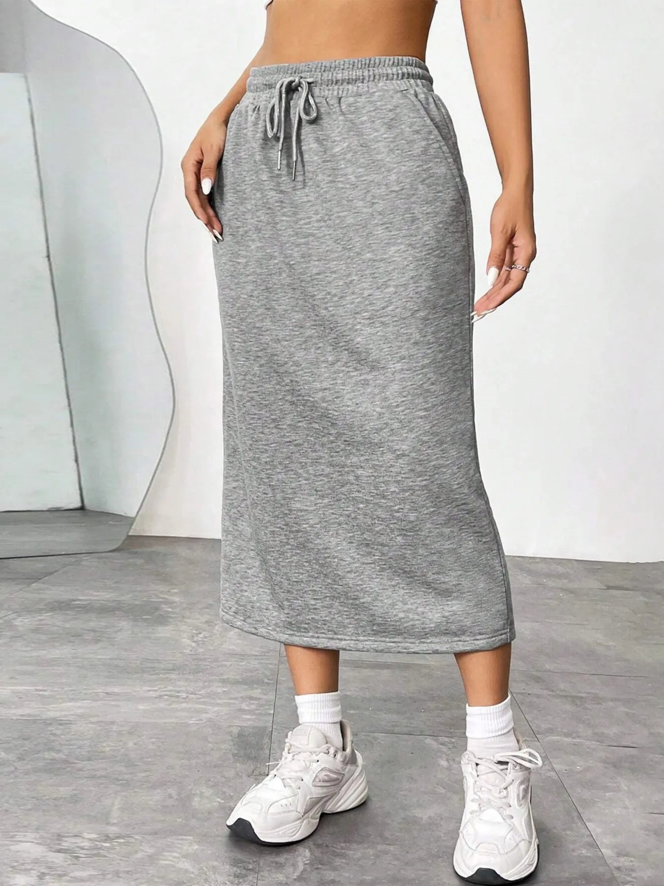 Trendsi slit drawstring midi skirt in flowy fabric with side slit and adjustable waistband, styled for a chic, casual look.