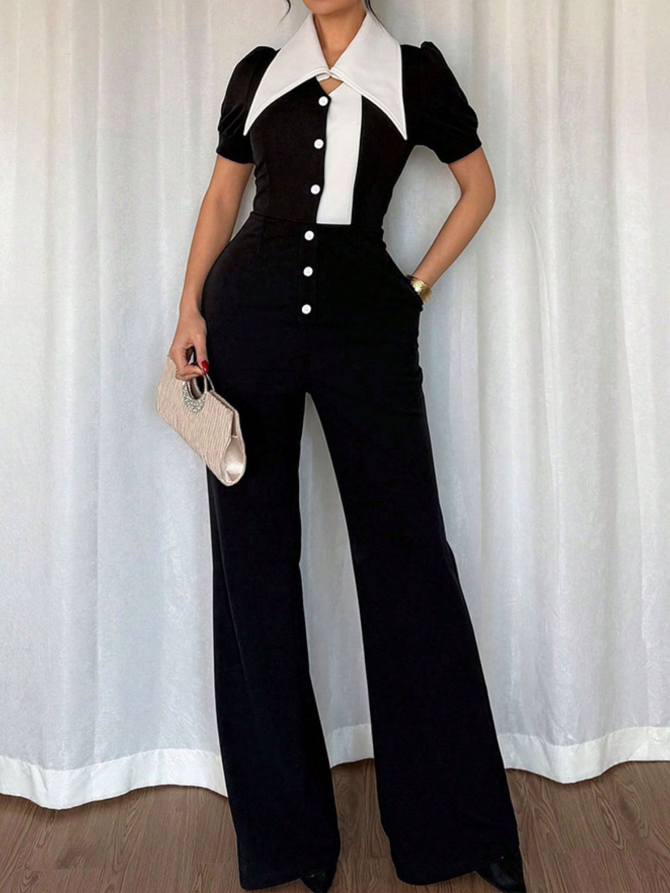 Black contrast button-down wide-leg jumpsuit from Trendsi, featuring a stylish jumpsuit design with a relaxed fit and flowy legs.
