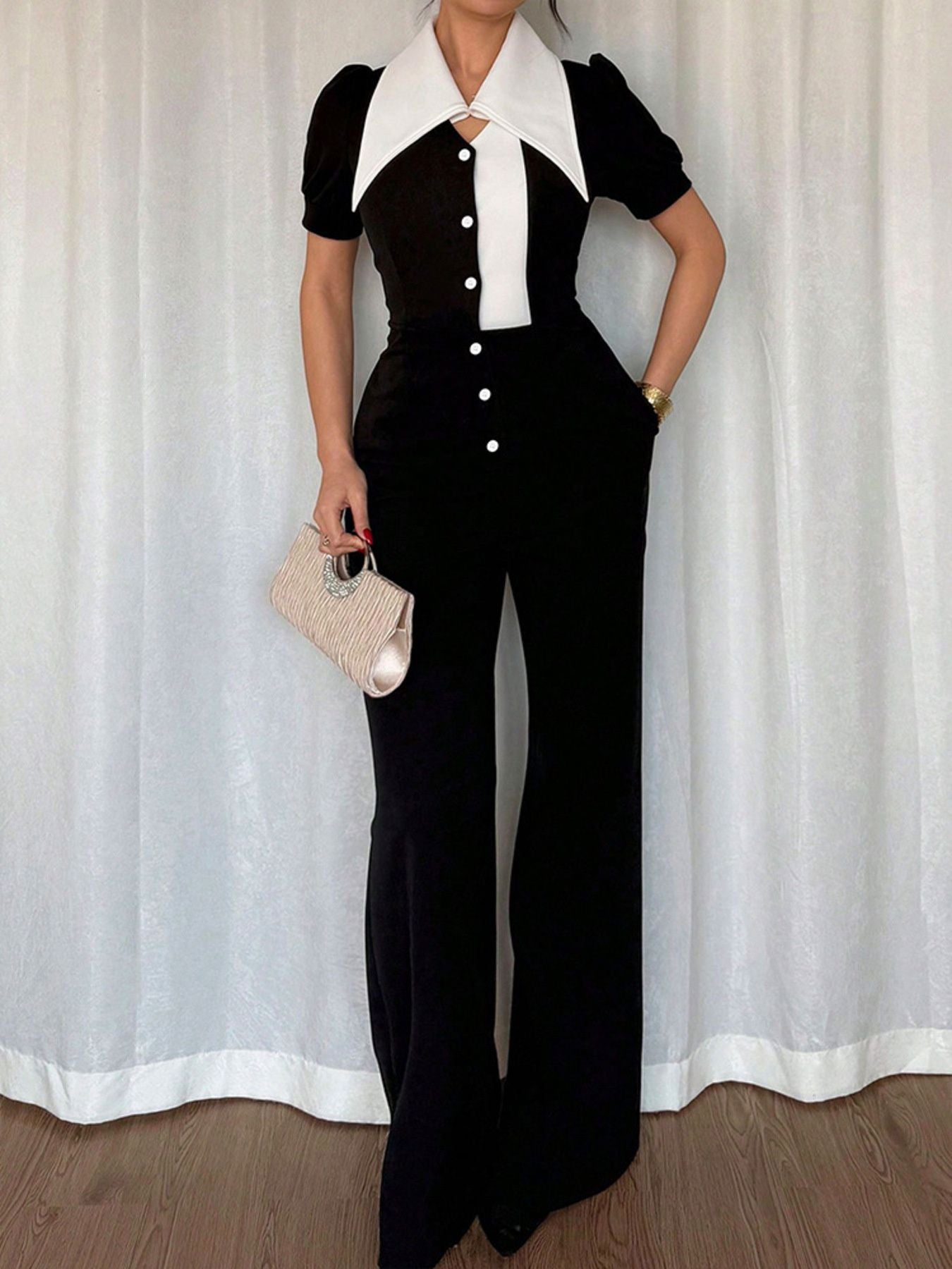 Black contrast button-down wide leg jumpsuit by Trendsi, featuring a stylish fit and comfortable wide-leg design.