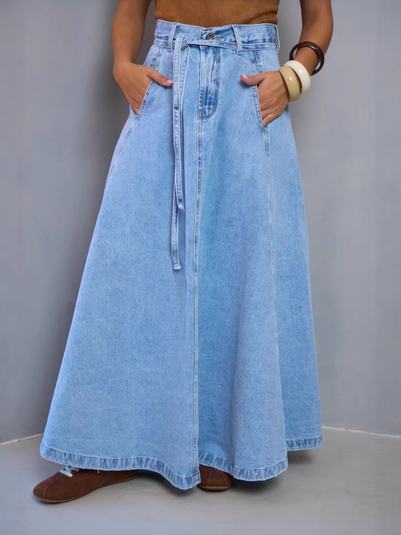 Light blue high-waisted denim skirt from Trendsi, styled with belt loops and a classic five-pocket design.