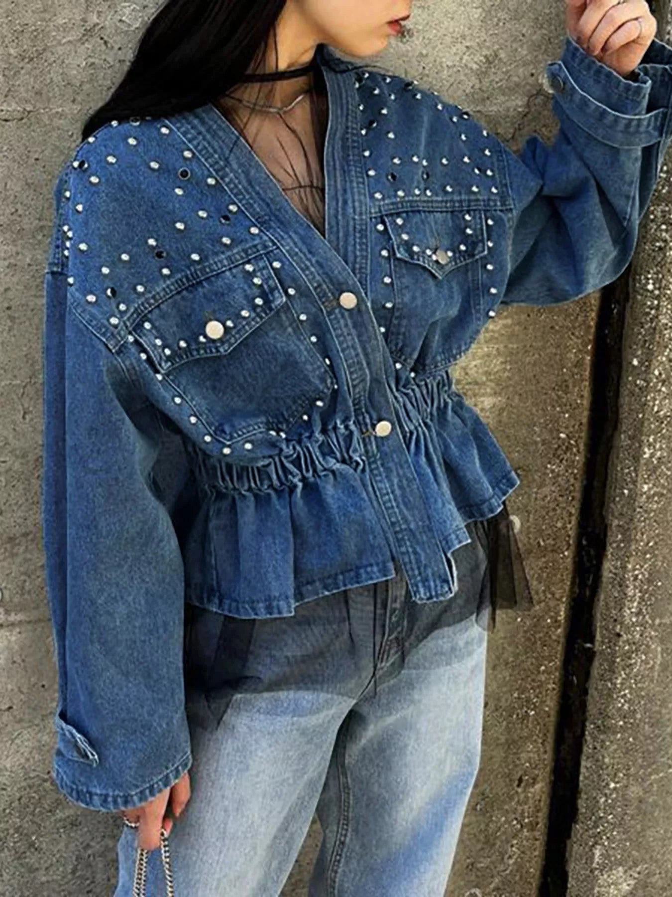 Light blue studded button-up denim jacket by Trendsi, featuring metal studs and classic denim style with collar and front pockets.