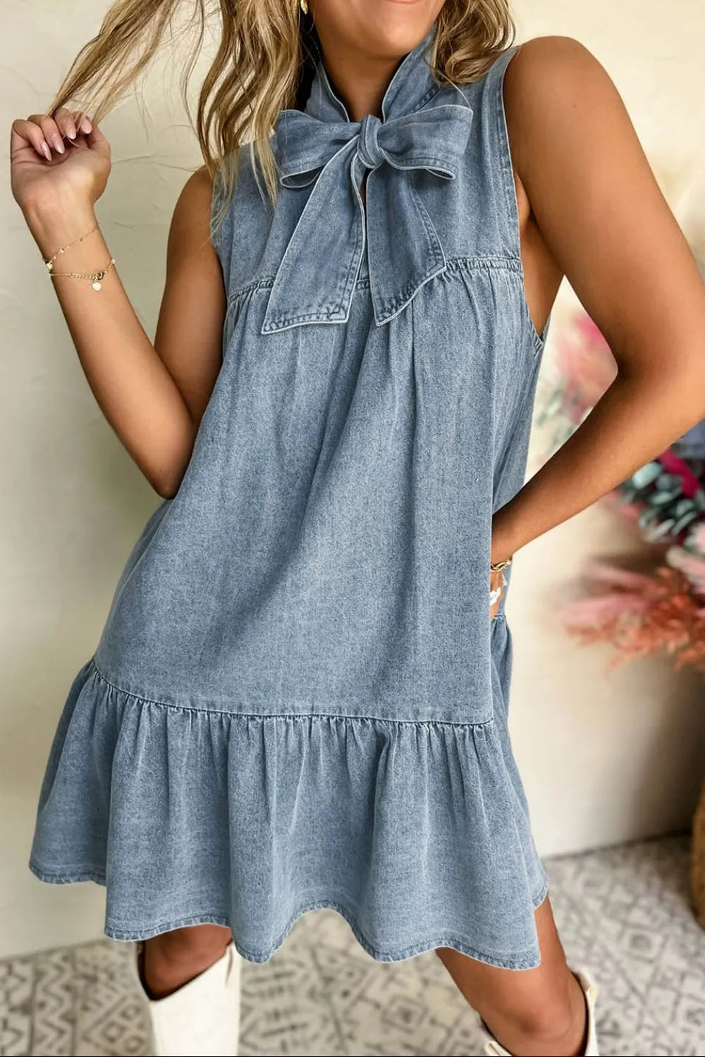 Light blue sleeveless denim dress with tie-neck detail by Trendsi, showcasing a casual, stylish summer dress design.