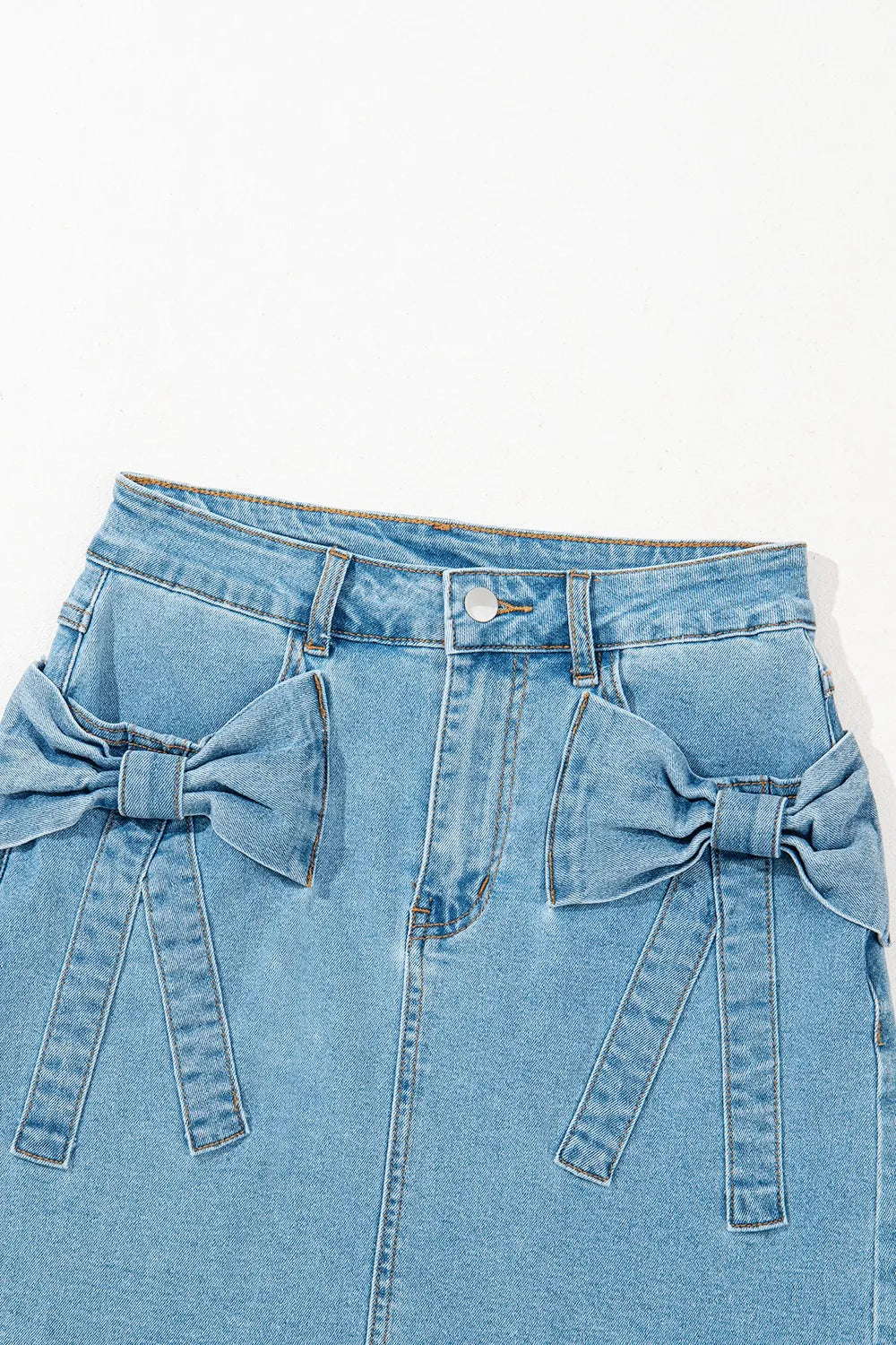 Light blue acid wash high waist denim skirt with bowknot details and a fitted silhouette, perfect for casual and trendy outfits.