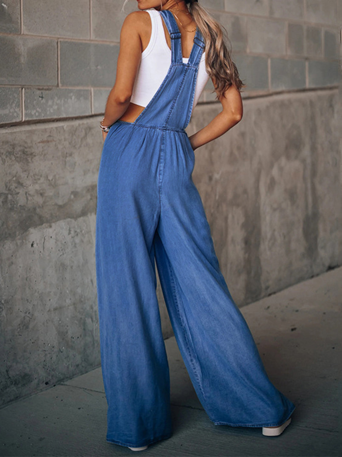 Medium-sized Trendsi wide leg denim overalls with adjustable straps and front pockets, styled with casual footwear.