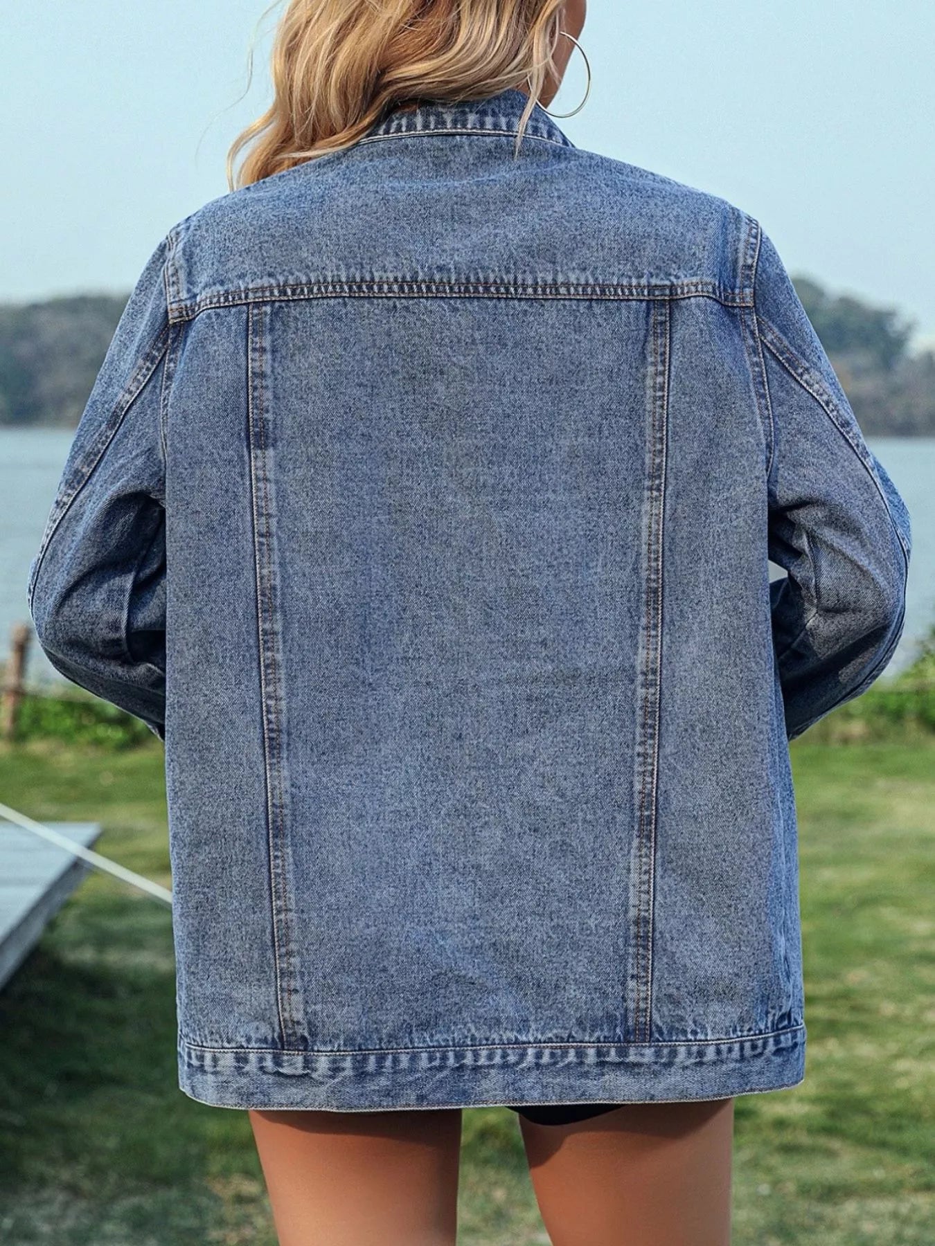 Studded button-up denim jacket by Trendsi featuring silver studs on classic blue denim with front pockets and button closure.