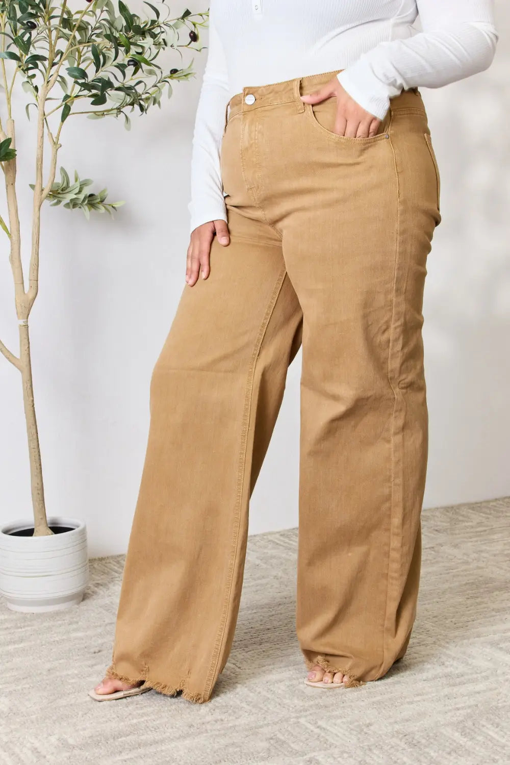 Risen full size wide leg jeans with fringe hem, showcasing relaxed fit and trendy style in denim fabric.
