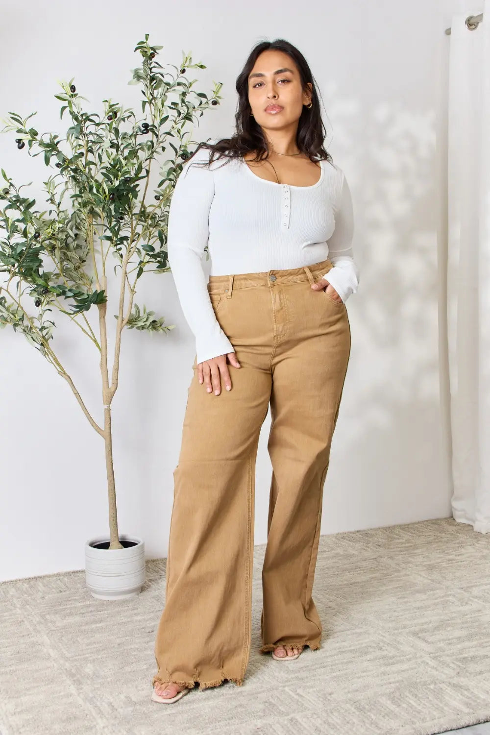 Risen full size fringe hem wide leg jeans with distressed details, high waist, and relaxed fit, styled for casual wear.