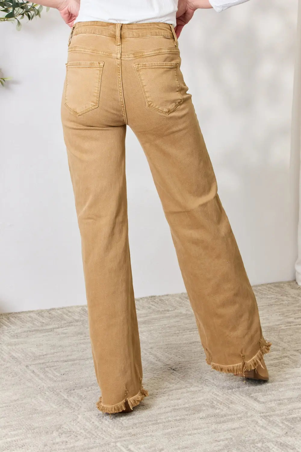 Risen full size wide leg jeans with fringe hem, trendy distressed denim from Trendsi, shown on a model.