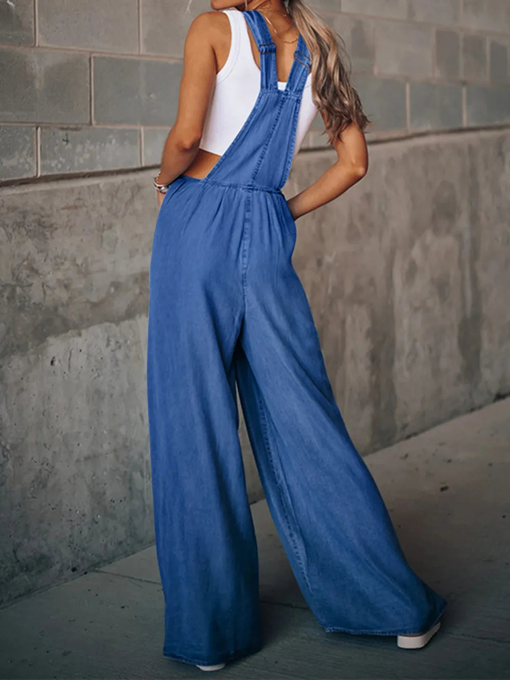 Distressed wide-leg denim overalls, trendy one-piece by Trendsi with a relaxed fit and casual style, shown on a model.