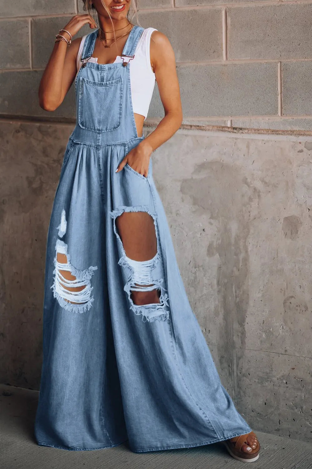 Distressed wide-leg denim overalls by Trendsi, a casual one-piece jumpsuit with a relaxed fit and fashionable distressed details.