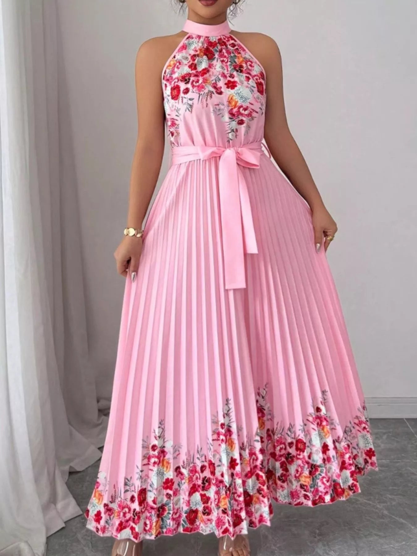 Pink halter neck floral print pleated maxi dress from Trendsi, flowing fabric and elegant design for summer occasions.