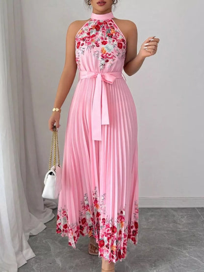 Pink halter neck floral print pleated maxi dress by Trendsi, showcasing flowing fabric and elegant design.