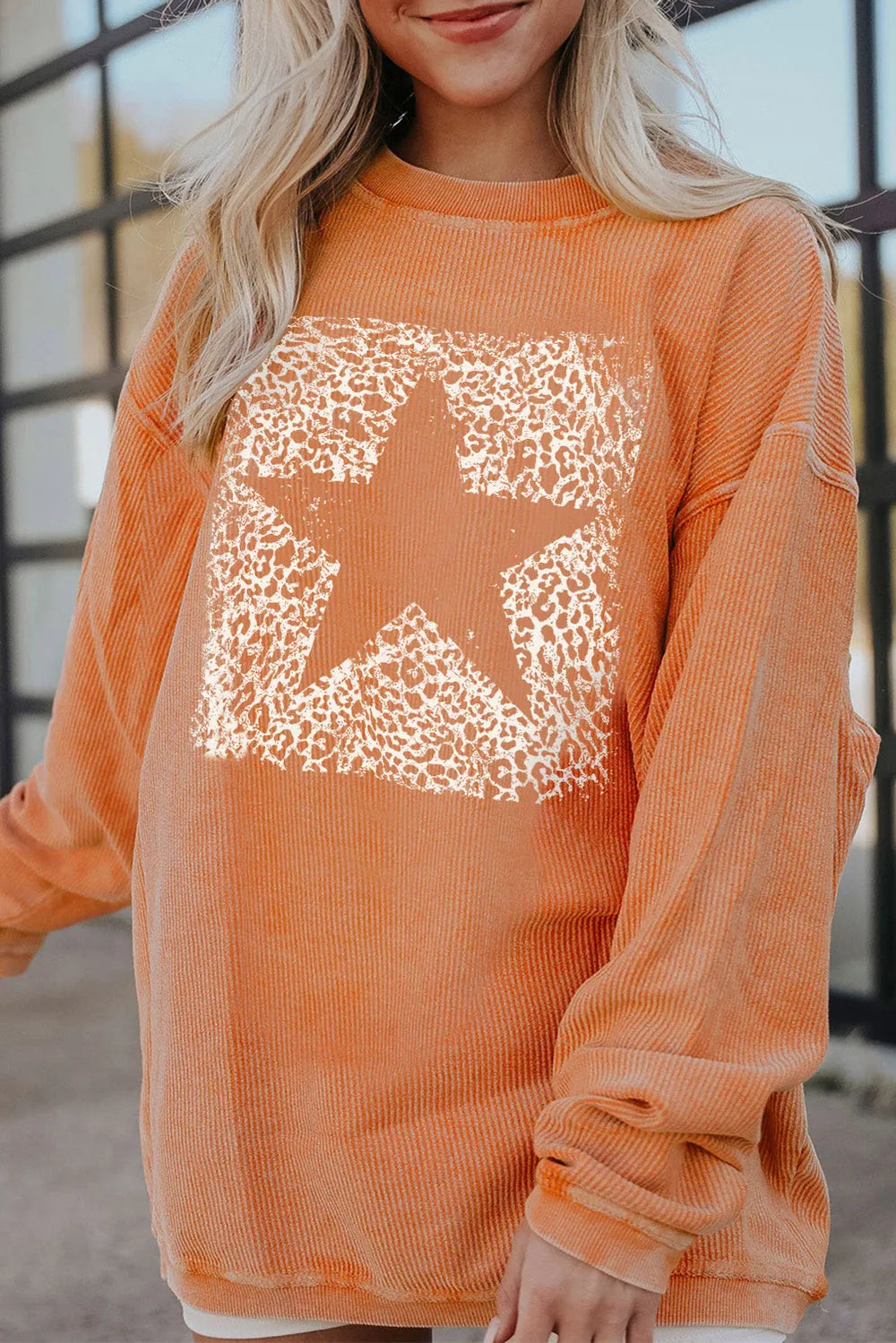 Oversized star sweatshirt from Trendsi in sherbet color, featuring a cozy fit and casual style for comfortable everyday wear.