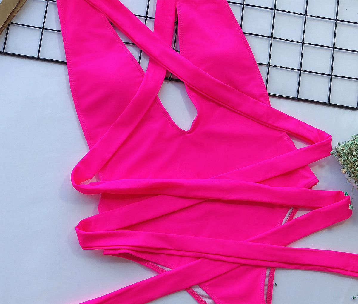 Hot pink halter neck deep V tied one-piece swimsuit by Trendsi, featuring a stylish swimwear design and flattering fit.