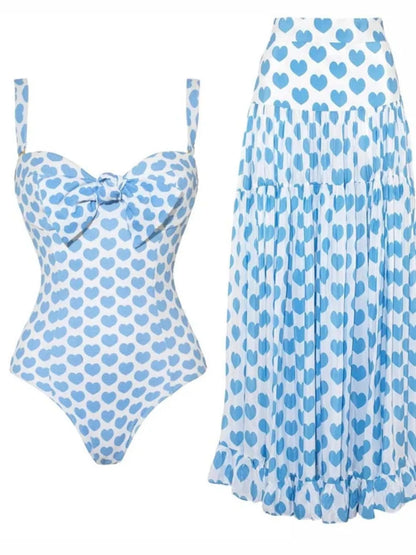 Pastel blue printed one-piece swimwear with matching skirt set by Trendsi, stylish and comfortable for beach or pool days.