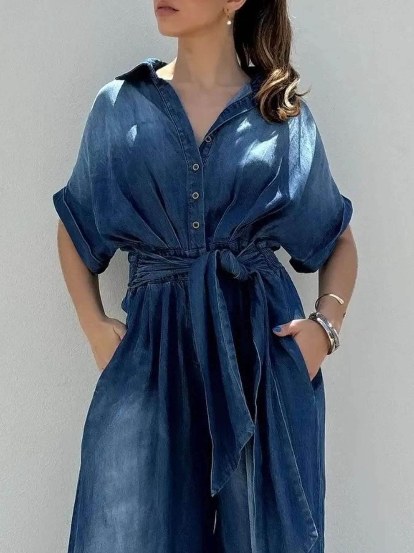 Vintage blue denim jumpsuit with button front and wide-leg design by Trendsi, featuring a casual and stylish fit.