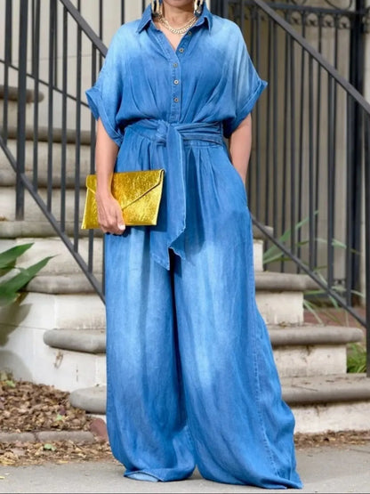 Vintage blue Trendsi button front wide-leg denim jumpsuit with long sleeves and front pockets, styled for casual wear.