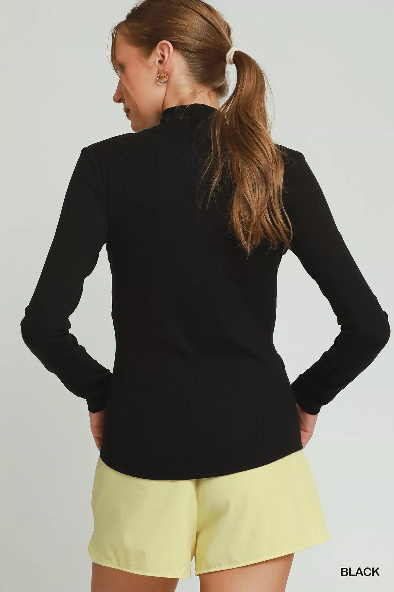 Black Umgee long sleeve mock neck top for women, stylish and comfortable, shown on a model.