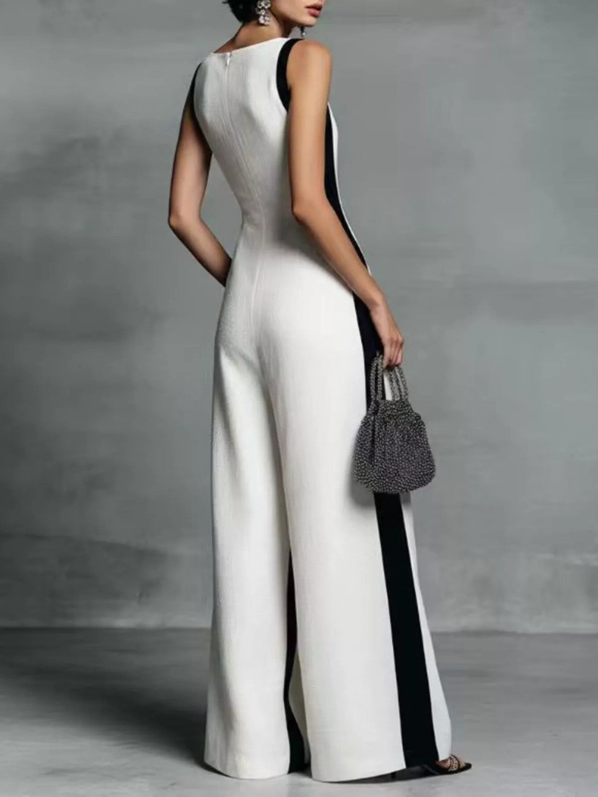 Deep V-neck wide-leg jumpsuit with contrast trim, featuring a stylish silhouette and modern design, displayed on a neutral background.