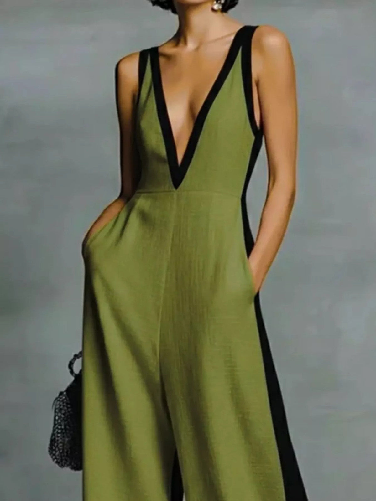 Deep V-neck wide-leg jumpsuit with contrast trim, unbranded, shown on a model with a sleek, modern style.